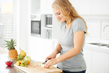 Image showing Woman, cooking and fruit for health food and nutrition for weight loss diet and health at home. Kitchen, organic fruits and cut banana in a house with breakfast and nutritionist in the morning