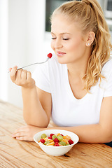 Image showing Fruit, wellness and woman eating healthy food for lunch or breakfast meal or diet in the morning in her home kitchen. Nutrition, health and vegan person smile and happy for salad, food and self care