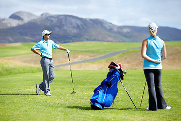 Image showing Couple, teamwork or golfer playing golf for fitness, workout or exercise together on green course field. Healthy people, woman golfing or athlete training in action or sports game driving with clubs