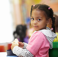 Image showing Break, child and food in classroom with portrait for learning in kindergarten on table for eating. Lunch, girl and education with bread at school or creche on desk for nutrition or breakfast.