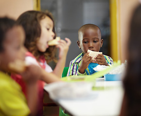 Image showing Eating, boy and children class for lunch at school or creche for an education or to learn. Break, kid and sandwich in a classroom to eat or learning or hungry at desk for nutrition with friends.