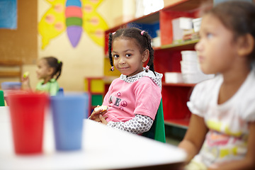 Image showing Child, classroom and lunch in portrait with smile for education at a table with children. Break, kids and learning at school with apple in kindergarten with chair or desk with food with friends.