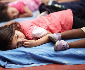 Image showing Kindergarten, children and group sleeping, relax and resting after education. Nursery, sleep and tired students take nap to rest together after learning, studying and knowledge in preschool classroom