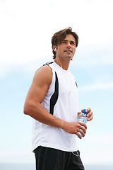 Image showing Thinking, running and a man with water and music after a workout, exercise or outdoor cardio. Break, relax and a runner with a drink while listening to a podcast after training or sports in nature