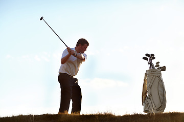 Image showing Stroke, golf and man with driver on course outdoor for training, workout or fitness on blue sky mockup space. Golfing, club and person swinging for game, competition or exercise, sports and wellness.