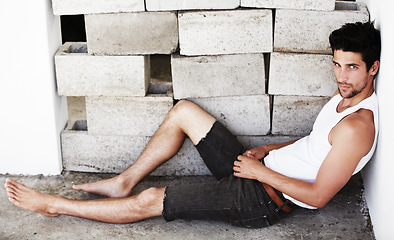 Image showing Portrait of sexy man, handsome and wall background with beauty, glow and confidence sitting on floor. Attractive, confident and serious face of male model on brick backdrop with thoughtful expression