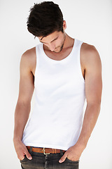 Image showing Thinking, casual style and man with white background in a studio with modern fashion. Isolated, male model and vest of a young person with hands in pocket contemplating looking down alone with idea