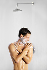 Image showing Shower, man and home with body cleaning and soap in the morning in bathroom. Water, young male person and smile with hygiene and clean skin care in a house with cosmetic grooming and shaving foam