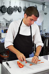 Image showing Chef, cooking and cutting with man in kitchen for luxury, hospitality and food catering. Fine dining, gourmet and dinner with male cook in hotel restaurant for menu, cuisine and meal preparation