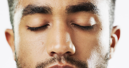 Image showing Closeup, face and serious man in studio for skincare eyes closed, confident and handsome against white background. Zoom, young and portrait of Indian male model with wellness, beauty or cosmetic rout