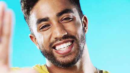 Image showing Selfie, laughing and face of a man with a smile isolated on a blue background in a studio. Happy, cheerful and portrait of a young guy taking a photo, smiling and posing for a picture on a backdrop