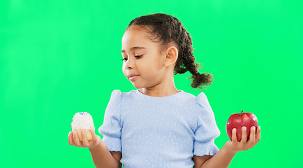 Image showing Face, confused and child on green screen with apple, candy and deciding in studio on mockup background. Portrait, fruit or dessert for girl unsure, doubt and contemplating snack while posing isolated