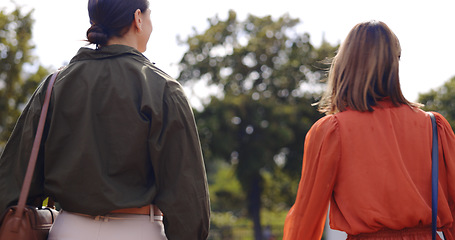 Image showing Nature, walking and women friends in conversation while bonding and spending quality time together. Talking, outdoor and back of females speaking while on a walk in a outside green garden or park.