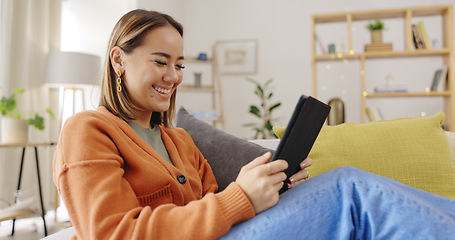 Image showing Home, happy and asian person relax on couch with digital technology and online web chatWoman, home and tablet on home sofa with internet connection for streaming video or movie online.