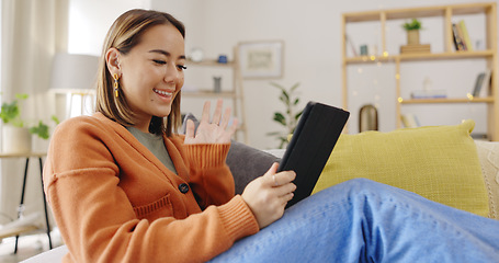 Image showing Video call, sofa and woman on tablet waves hello for virtual communication, talking and social networking. Home, happy and asian person relax on couch with digital technology and online web chat