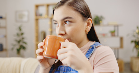 Image showing Relax, thinking and a woman drinking coffee on the sofa for happiness, peace and morning break. Sitting, living room and a girl with a warm beverage, tea drink and relaxing on the couch at home