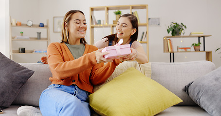 Image showing Home, lesbians and couple with a surprise, gift and bonding in living room, happiness and relax. Partners, women and queer people in their lounge, present and celebrate relationship, marriage and wow