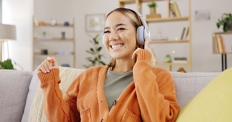 Image showing Headphones, home and happy woman listening to music for mental health, youth radio and streaming on sofa. Young asian person or relax with audio technology in living room, couch or apartment for Kpop