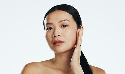 Image showing Skincare, asian woman and touch face in studio for beauty, dermatology or cosmetics on white background. Female model, portrait and facial aesthetic glow of shine, laser transformation and wellness