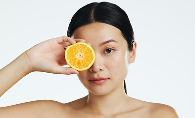 Image showing Orange fruits, skincare and face of woman in studio, white background and cosmetics. Beauty model, asian female and portrait of citrus for vitamin c, natural detox and healthy aesthetic dermatology