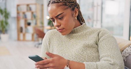 Image showing Worried, woman on couch and smartphone with concerned expression, watching videos in living room. African American female, lady and cellphone with network signal, social media or connection for commu