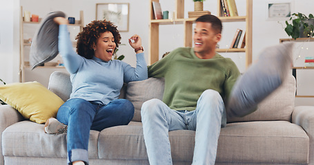 Image showing Pillow fight, happy couple and fun in living room for love, silly game and energy at home. Cushion, fighting and excited man being playful with young woman, partner and laughing together on couch