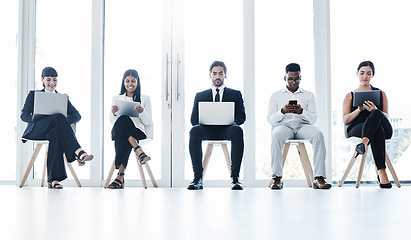 Image showing Group, business people and chair with tech in queue, diversity or waiting room for hr recruitment. Men, women and technology for interview, human resources or research for hiring, job or opportunity