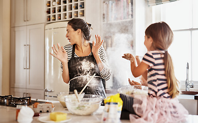 Image showing Mother, playing or girl baking in kitchen as a happy family with a playful young kid with flour at home. Dirty, messy or funny mom helping, cooking or teaching daughter to bake for child development