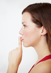 Image showing Secret, hand and woman with finger on lips in studio for gossip, privacy or sign on white background. Whisper, profile and female person with silence, confidential or emoji with drama or announcement