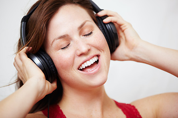 Image showing Music, headphones and singing by happy woman in studio with audio, track or song on white background. Earphones, face and female person streaming podcast, radio or online playlist and subscription