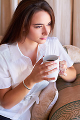 Image showing Relax, woman drinking her coffee in the morning and thinking on sofa in the living room of her home. Peace or freedom, health wellness and female person drink hot beverage for stress relief