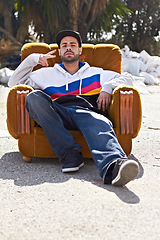 Image showing Portrait, man and hand with peace sign in street, urban fashion and relax with cool streetwear style in the city. Person, face and stylish model with cap relaxing, chair or outdoor couch and sofa