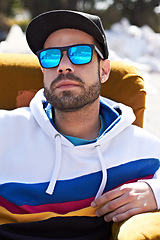 Image showing Face, fashion and man with glasses in a city, chill and attitude, young and stylish on blurred background. Trendy, sunglasses and male person with confidence, casual and cool clothes while downtown