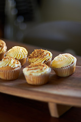 Image showing Cupcake, dessert and bakery confectionery closeup, presentation and food with sweet baked goods. Luxury snack, frosting and sprinkles, hospitality and catering industry with cake on wooden table