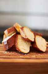 Image showing Cooking, food and bakery with bread in kitchen for nutrition, health and diet. Breakfast, cafe and coffee shop with closeup of product on cutting board on table for wheat, grain and wellness