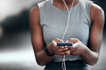 Image showing Smartphone, hands or girl in gym on social media to relax on break after fitness training or workout break. Headphones, texting or healthy sports athlete with mobile app for online or digital content