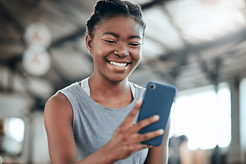 Image showing Social media, happy or black woman with phone in gym to search for a sports blog in training or exercise. Fitness app, smile or healthy girl athlete relaxing or reading online mobile content on break