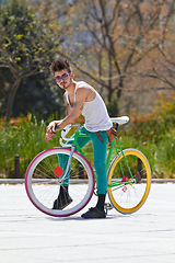 Image showing Cool man, fashion and portrait with bicycle in city, outdoor and in sunshine with unique personality. Young gen z guy, funky trend and hipster cycling on bike in summer, urban town and with attitude