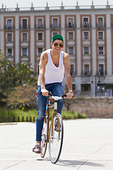 Image showing Happy, cycling and man on a bicycle in the city for practicing tricks and skills for competition. Activity, hobby and casual young male person training and riding outdoor with bike in urban town road