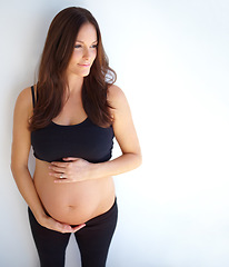 Image showing Thinking, pregnant and woman touching her stomach, future and health with wellness, nurture and growth. Female person, mother and girl with pregnancy, belly and ideas with happiness and development