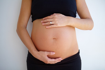 Image showing Pregnancy, woman and hands on stomach with love, care and support for healthy baby or maternity on white background. Pregnant, mother and hand on belly, tummy and wellness of body and motherhood