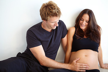 Image showing Pregnant, touching stomach and couple on a white background for love, care and support in studio. Future family, pregnancy and happy man and woman excited for bonding relationship, baby or parenthood