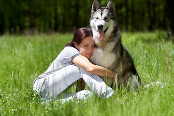 Image showing Woman, husky and smile in portrait, field or park with hug, love and bonding with care in summer sunshine. Girl, pet dog and happy in nature, woods or grass with embrace on adventure in countryside