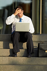 Image showing Laptop, outdoor and business man stress, worry and sad for job fail, online mistake or news, bankruptcy and financial crisis. Person headache, debt and stock market crash on city stairs and computer