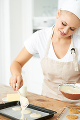 Image showing Happy woman, tray or chef baking cookies with dough or pastry in a bakery kitchen with recipe. Food business, dessert or girl baker smiling or working in preparation of a sweet meal, cake or biscuit