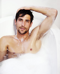 Image showing Portrait, hygiene and a sexy man in a bath in his home for soap cleaning, grooming or body care. Health, nude and beauty with a handsome young man lying in a luxury bathroom to relax or refresh