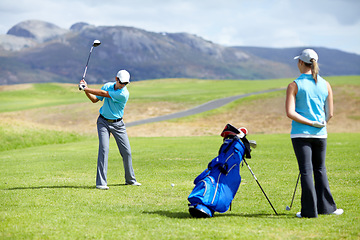 Image showing Swing, man or golfer playing golf for fitness, workout or exercise to drive on a green course. Woman, person golfing or athlete training in action or sports game driving with a club stroke on field