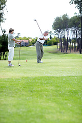 Image showing Old couple, sports or golfer playing golf for fitness, workout or exercise to swing on course or field. Senior woman, elderly man golfing or training in practice game to strike a ball in retirement