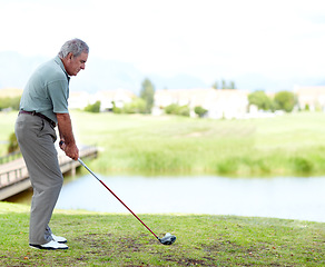 Image showing Senior, man or golfer playing golf for fitness, workout or exercise with a swing on a green course. Stroke, person golfing or mature player training in sports game driving with a club in retirement