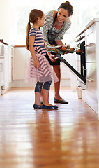 Image showing Mom, oven or kid baking in kitchen as a happy family with a young girl learning cookies recipe at home. Cake muffins, smile or mom helping or teaching daughter to bake in stove for child development